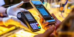Person scanning a QR code from a POS terminal on a smartphone to make a payment