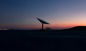 Satellite antenna at sunset, representing wireless connectivity and communication.