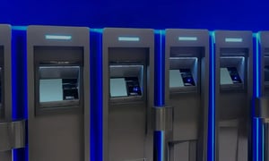 Multiple modern ATMs with illuminated blue lights in a row.
