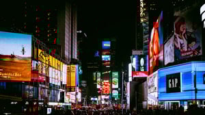 Bright digital billboards and advertisements in a busy cityscape at night