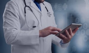 Doctor using tablet with stethoscope in healthcare setting