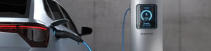 Electric vehicle charging at an EV station with a digital display showing charging status.