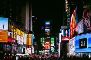 Bright digital billboards and advertisements in a busy cityscape at night