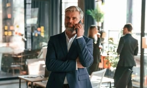 A businessman talking on his smartphone in a modern office.