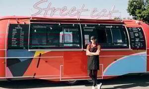 Street food truck vendor standing in front of a red food truck