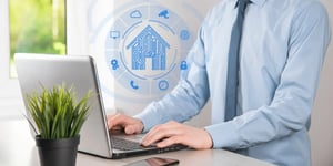 Person working on laptop with smart property management icon overlay