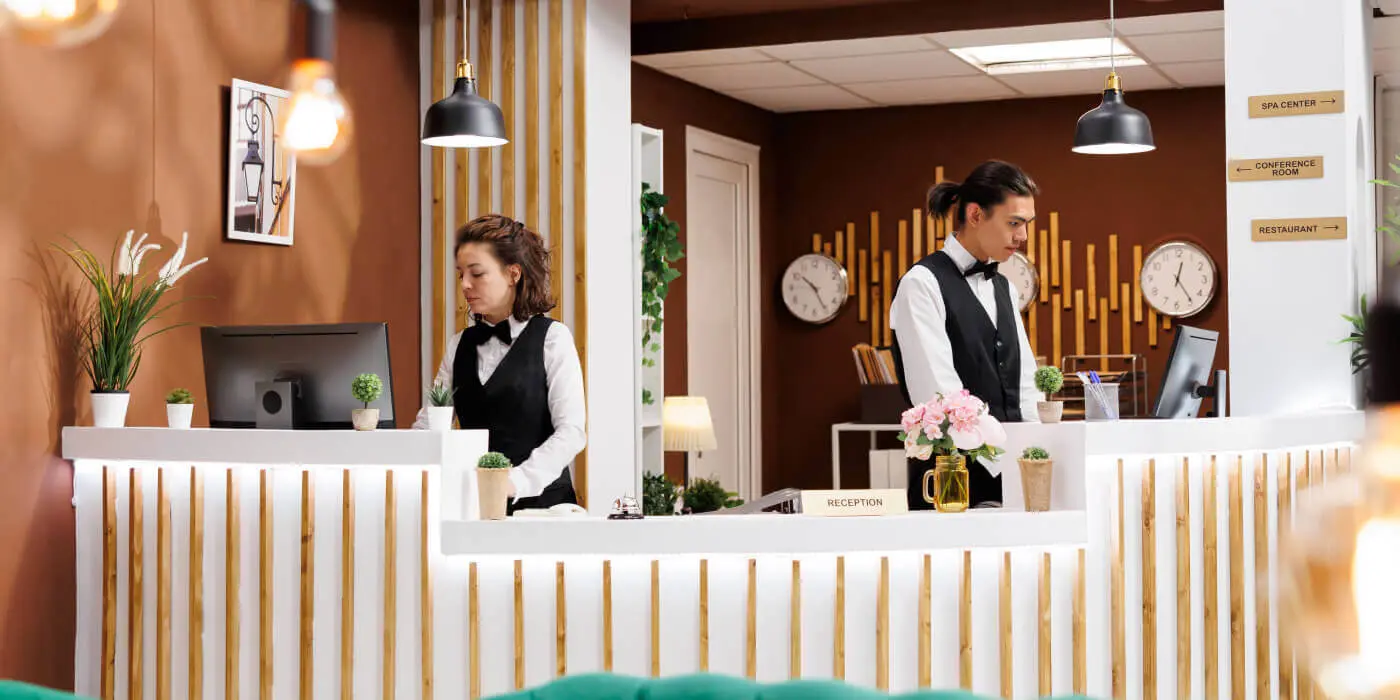 Hotel staff using connected systems at front desk Hotel staff using connected systems at front desk